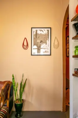 a wall with a picture and a plant on it at DAR MA ITTO Charming luxurious Medina Cocoon in Marrakech