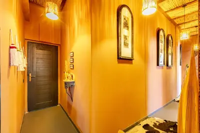 a hallway with yellow walls and a brown door at DAR MA ITTO Charming luxurious Medina Cocoon in Marrakech