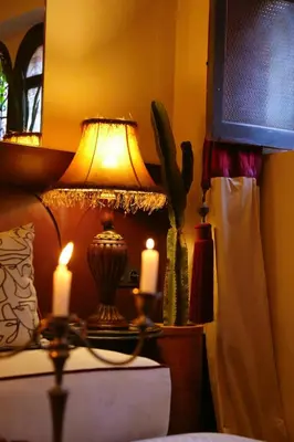 a lamp sitting on a table with two candles at DAR MA ITTO Charming luxurious Medina Cocoon in Marrakech
