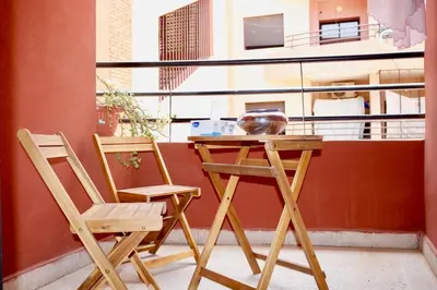 two chairs and a wooden table on a balcony at Nelbrj Studio in Marrakech