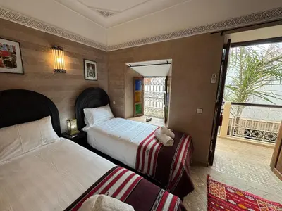 a hotel room with two beds and a window at Échappée onirique au cœur de Marrakech in Marrakech