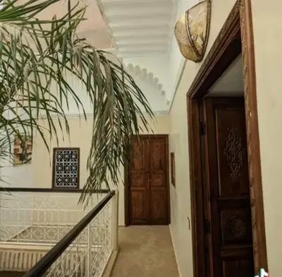 a hallway with a staircase and a wooden door at Échappée onirique au cœur de Marrakech in Marrakech