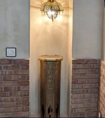 a chandelier hanging from a wall next to a brick wall at Échappée onirique au cœur de Marrakech in Marrakech