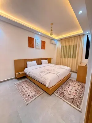 a bedroom with a large bed with two rugs at Orange Apartment With Pool in Marrakech