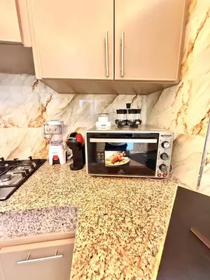 a microwave oven on a counter in a kitchen at Orange Apartment With Pool in Marrakech