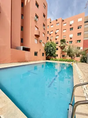 a large swimming pool in front of a building at Orange Apartment With Pool in Marrakech
