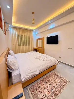 a bedroom with a bed and a flat screen tv at Orange Apartment With Pool in Marrakech