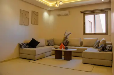 a living room with a couch and a table at 2 bedrooms appartement les palmiers de targa in Marrakech