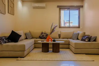 a living room with a couch and a table at 2 bedrooms appartement les palmiers de targa in Marrakech
