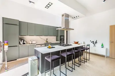 a kitchen with a kitchen island with purple chairs at Family villa in Marrakech in Marrakech