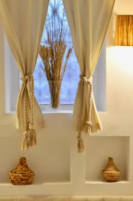 a window with curtains and vases on a shelf at Riad KITSCH in Marrakech