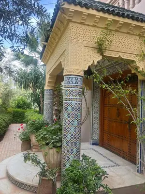 a house with a pillar and a garden at Villa Louise in Marrakech