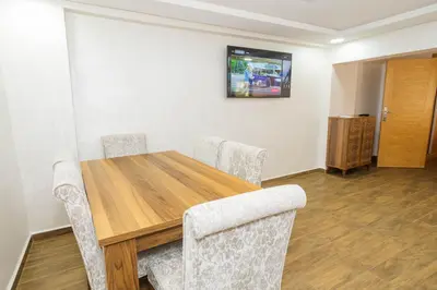 a dining room with a wooden table and chairs at Bonheur appartement in Marrakech