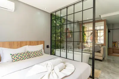 a bedroom with a large white bed with a glass wall at Luxury Balnéo appartement in Marrakech