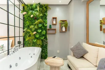 a bathroom with a green wall with a bath tub at Luxury Balnéo appartement in Marrakech