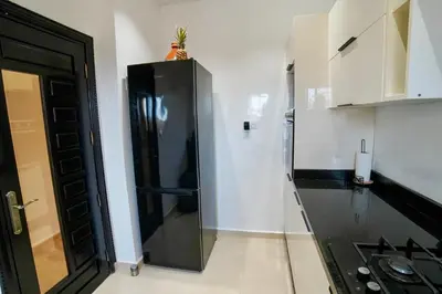 a black and white kitchen with a black refrigerator at Villa Dar Soka in Marrakech