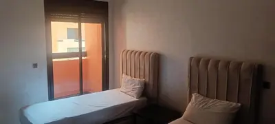 a couple of beds in a room with a window at premium village m231 in Marrakech