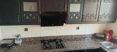 a kitchen with black cabinets and a stove top at premium village m231 in Marrakech