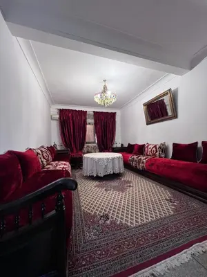 a living room with red couches and a table at Dar MI HNIA in Marrakech