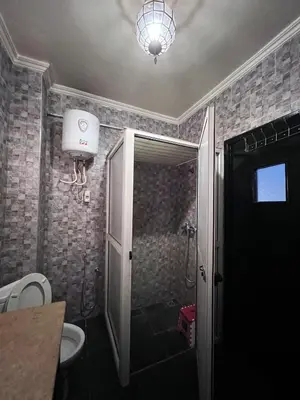 a bathroom with a shower with a toilet and a light at Dar MI HNIA in Marrakech