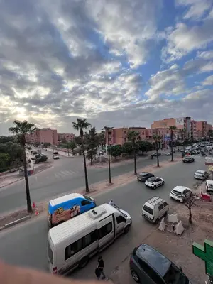 a street with cars and a bus parked in a parking lot at Dar MI HNIA in Marrakech