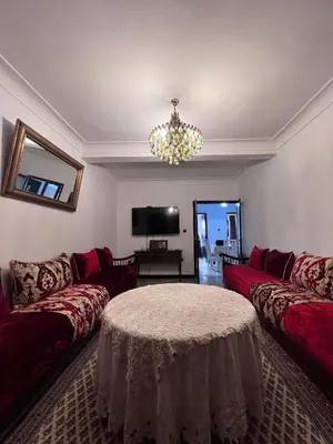 a living room with red couches and a chandelier at Dar MI HNIA in Marrakech