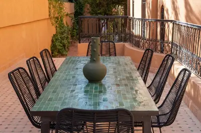 a green table with chairs and a vase on it at Villa ÈME in Marrakech