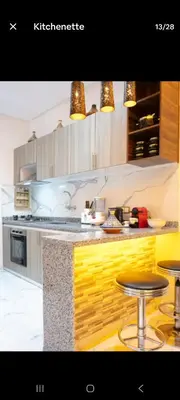 a kitchen with a counter and two stools at Appartement limoen in Marrakech