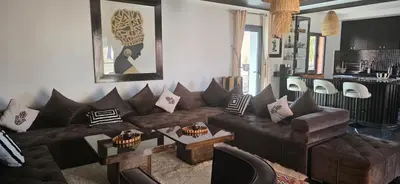 a living room with a brown couch and chairs at Design Art Gallery Apartment Marrakech swimming pool on the Roof in Marrakech
