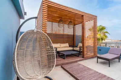 a wooden pergola with a couch and chairs on a deck at Design Art Gallery Apartment Marrakech swimming pool on the Roof in Marrakech