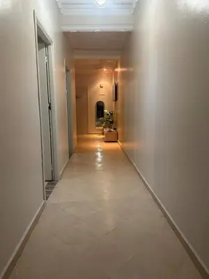 an empty hallway with a white wall and a tile floor at Modern Comfort, Local Vibes in Marrakech