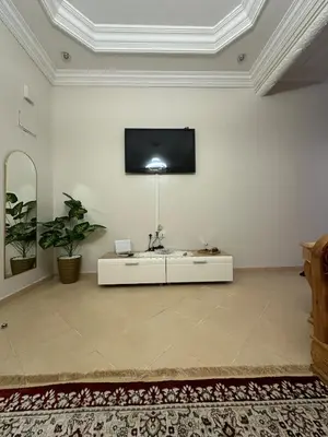 a living room with a tv on a white wall at Modern Comfort, Local Vibes in Marrakech