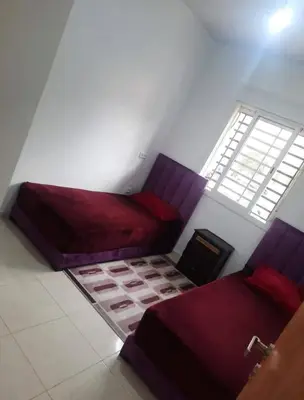 a room with two beds and a window at Shawna Home in Marrakech