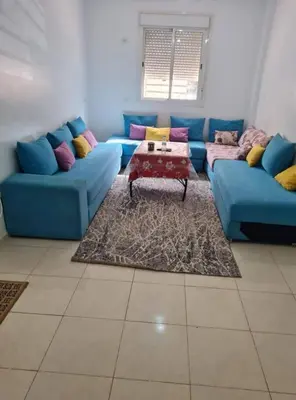 a living room with a blue couch and a table at Shawna Home in Marrakech