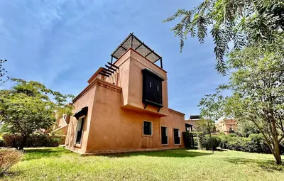 a building with a tower on top of a yard at Private Garden Villa - Rooftop, BBQ, Pools and Views in Marrakech