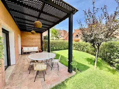 a patio with a table and chairs under a pergola at Private Garden Villa - Rooftop, BBQ, Pools and Views in Marrakech