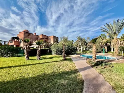 a resort with a swimming pool and palm trees at Private Garden Villa - Rooftop, BBQ, Pools and Views in Marrakech
