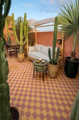a patio with a couch and a table and cactus at PRIVATE HOUSE in Medina Close to Jeema El Fna in Marrakech