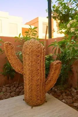 a wicker vase sitting on a table with its arms up at Cosy, Bohème au cœur de Marrakech et de la medina in Marrakech