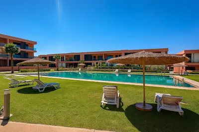 a pool with chairs and umbrellas next to a building at Cosy, Bohème au cœur de Marrakech et de la medina in Marrakech