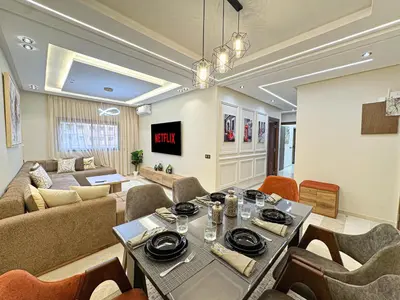 a living room with a table and a couch at Perle de Marrakech avec Piscine et Parking in Marrakech