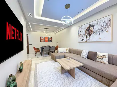 a living room with a couch and a tv at Perle de Marrakech avec Piscine et Parking in Marrakech