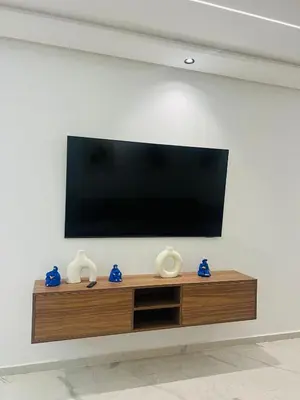 a flat screen tv on a wall with vases at Monolocale l'alba Hevernage 1ch in Marrakech