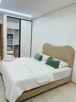 a bedroom with a large white bed with green pillows at Monolocale l'alba Hevernage 1ch in Marrakech