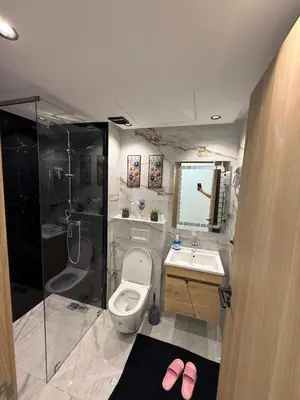 a bathroom with a toilet and a sink and a shower at L'aube de l'éveinage 2 bedrooms Marrakech station in Marrakech