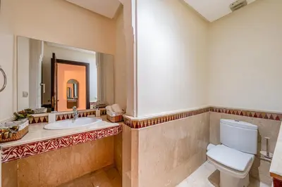 a bathroom with a toilet and a sink and a mirror at Urban Pearl terrace and pool in Marrakech