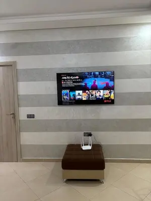 a wall with a tv on a striped wall at cozy and warm apartment in Marrakech