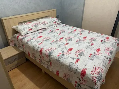 a bed with a red and white comforter on it at cozy and warm apartment in Marrakech