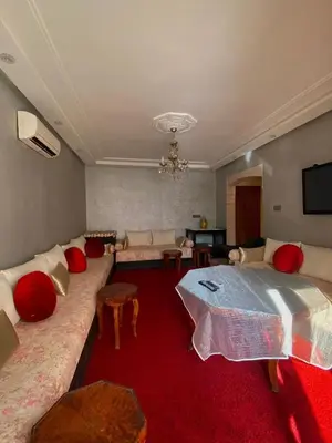 a living room with a large couch and red carpet at Modern 2-Bedroom Apartment in Gueliz in Marrakech