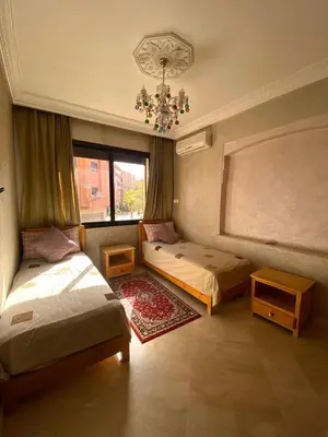 a bedroom with two beds and a chandelier at Modern 2-Bedroom Apartment in Gueliz in Marrakech